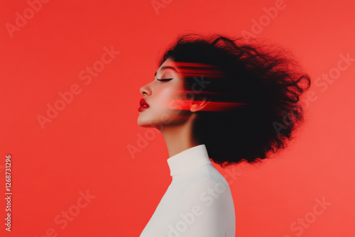 Model posing with red light trails and red lipstick on red background