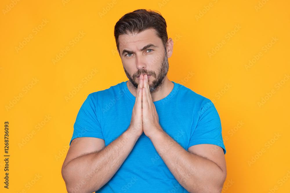Christian Religion. Man praying. Isolated portrait of male pray. Closeup portrait of man praying hands, hoping isolated on yellow background. Human pray. Christian Religion. Man praying. Isolated portrait of male pray. Closeup portrait of man praying hands, hoping isolated on yellow background. Human pray.