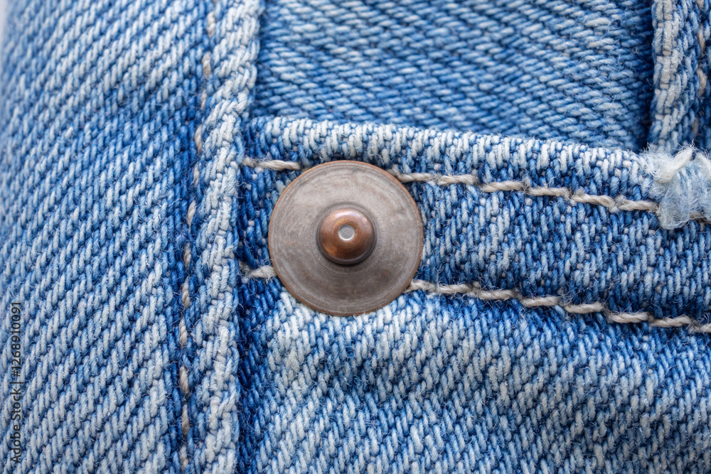 Old metal button closeup on blue jeans Old metal button closeup on blue jeans