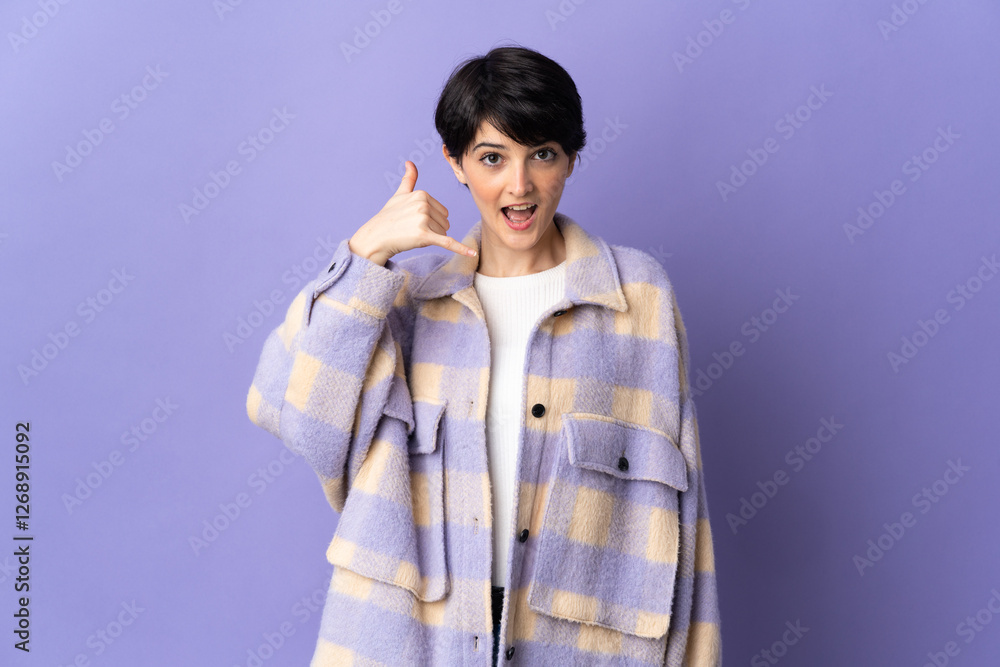 Woman with short hair isolated on purple background making phone gesture. Call me back sign Woman with short hair isolated on purple background making phone gesture. Call me back sign