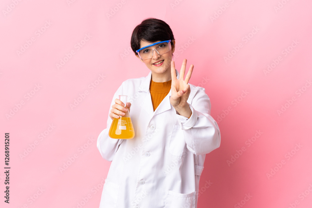 Young scientific woman isolated on pink background happy and counting three with fingers Young scientific woman isolated on pink background happy and counting three with fingers