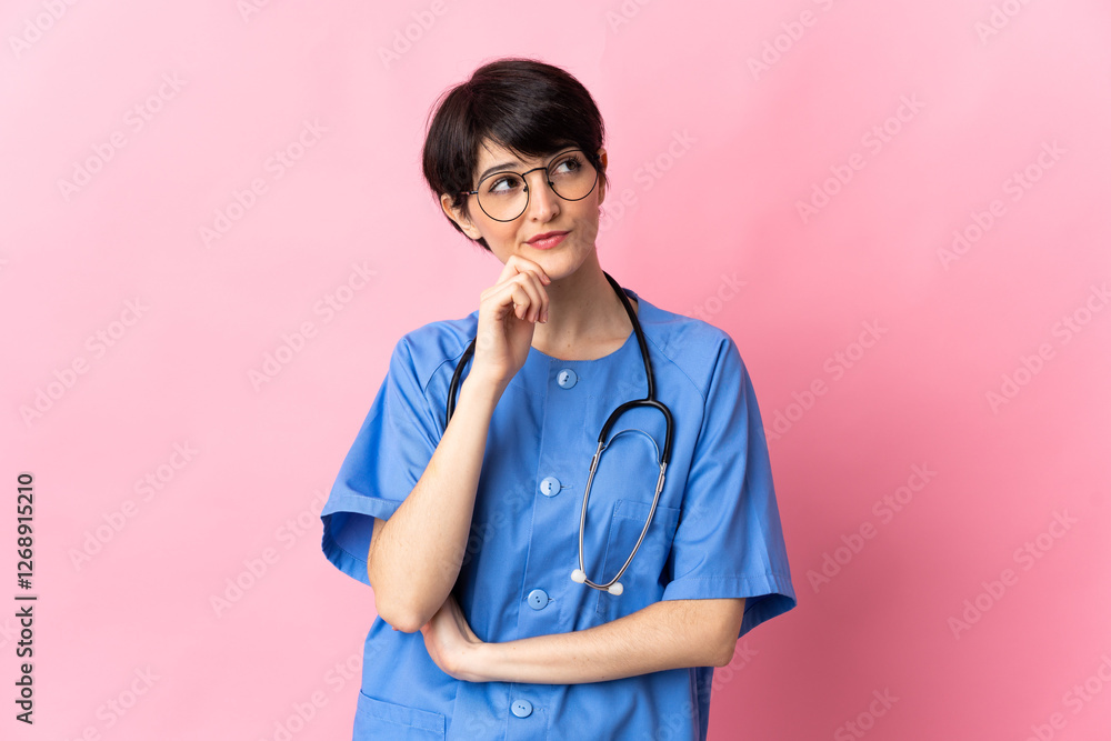 Surgeon isolated on pink background and looking up Surgeon isolated on pink background and looking up