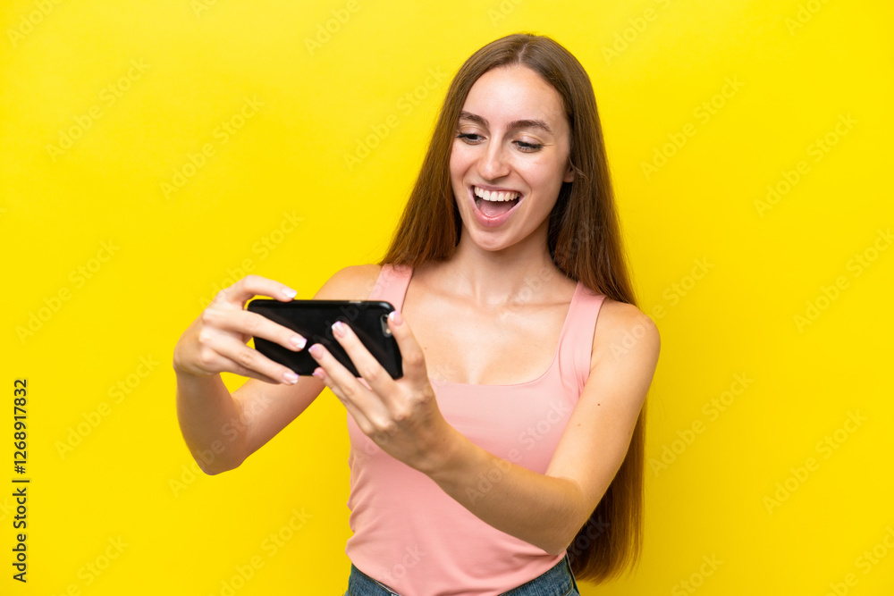 Young caucasian woman isolated on yellow background playing with the mobile phone Young caucasian woman isolated on yellow background playing with the mobile phone