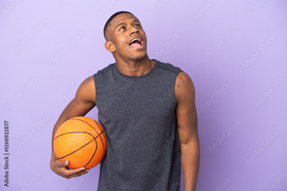 Young basketball latin player man isolated on purple background laughing Young basketball latin player man isolated on purple background laughing