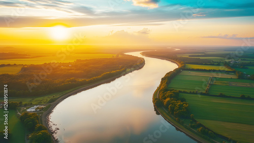 Wide aerial view of a river winding through green fields at sunset, symbolizing nature, tranquility, rural landscapes, and the beauty of the natural world photo