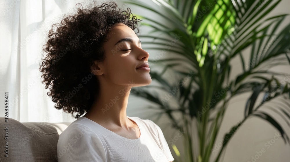 In a tranquil indoor setting, a woman with curly hair sits calmly, enjoying the warmth of sunlight In a tranquil indoor setting, a woman with curly hair sits calmly, enjoying the warmth of sunlight