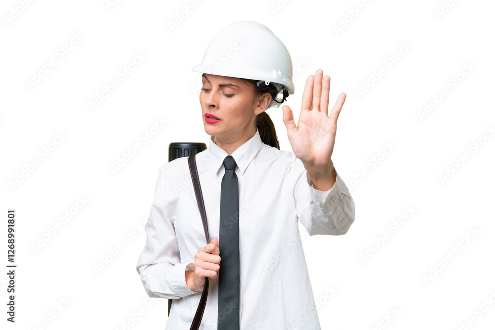 Young architect woman with helmet and holding blueprints over isolated background making stop gesture and disappointed Young architect woman with helmet and holding blueprints over isolated background making stop gesture and disappointed
