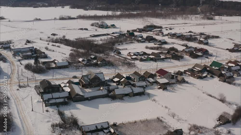 Snowy Russian village nestled amid white landscape, revealing picturesque rural settlement with traditional houses under bright sunny winter sky from overhead perspective Snowy Russian village nestled amid white landscape, revealing picturesque rural settlement with traditional houses under bright sunny winter sky from overhead perspective