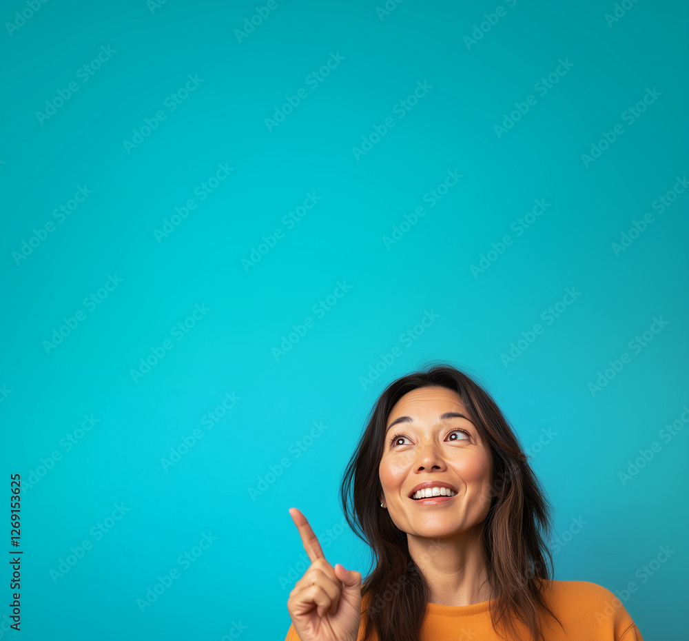 asian ethnicity beautiful brunette woman smiling and showing something with finger pointing gesture; open mouth smile; happy lady isolated over blue background