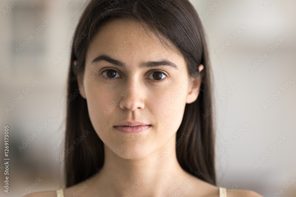 Cropped close up portrait calm face of beautiful female teenager with brown eyes long dark hair smooth healthy skin looking at camera. Skincare self care natural beauty of youth or confidence concept Cropped close up portrait calm face of beautiful female teenager with brown eyes long dark hair smooth healthy skin looking at camera. Skincare self care natural beauty of youth or confidence concept
