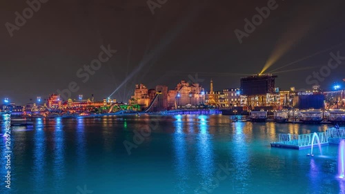 Panorama showing Riyadh Boulevard World entertainment park with illuminated attractions famous landmarks. Largest artificial lake on the world with floating boats night timelapse. Riyadh. Saudi Arabia