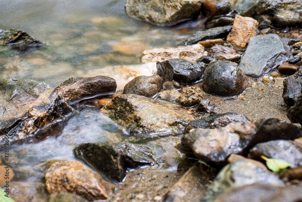 Flowing water over wet stones in a riverbed
Flowing water over wet stones in a riverbed