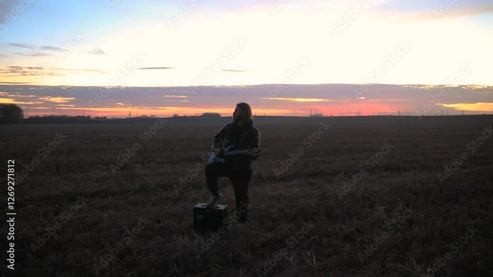 man playing electric guitar in leather jacket at sunset man playing electric guitar in leather jacket at sunset