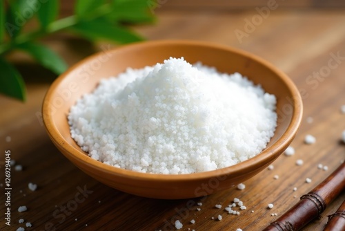 Freshly harvested salt scattered on a smooth bamboo plate, grain, natural, wood