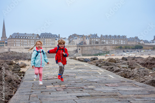 Obraz na płótnie Children enjoying joyful run on a seaside walkway in Saint-Malo w salonie