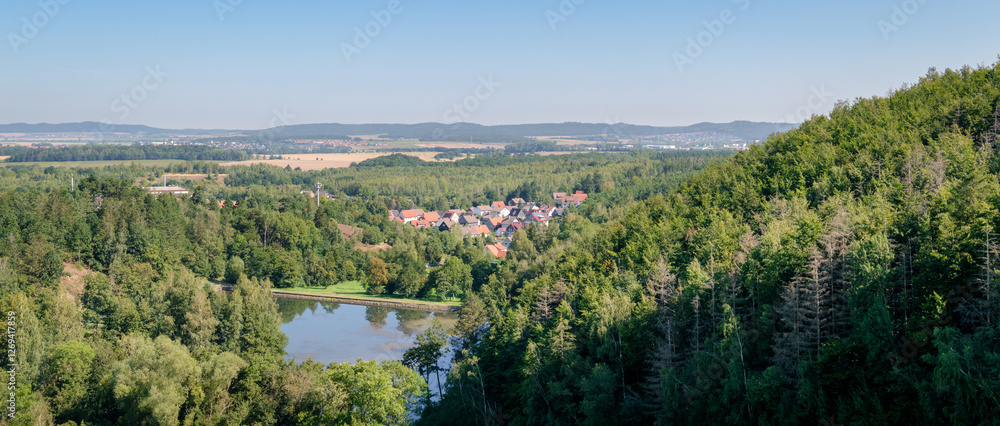 Obraz premium The village of Astfeld can be seen while standing on the barrier of the Granetalsperre or Grane Dam on a August summer morning. It is located near Goslar, in the western Harz region