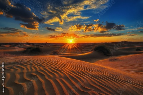 Sunset over wind-swept sand dunes in a vast desert landscape during golden hour