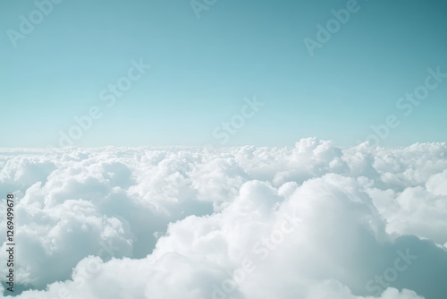 Fluffy clouds under a clear blue sky creating a serene and peaceful atmosphere in a natural landscape photo