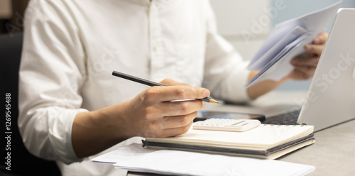 close up young man hand press on calculator and open over group of invoice letter mail from bank after pass due date of payment for money and debt management concept	