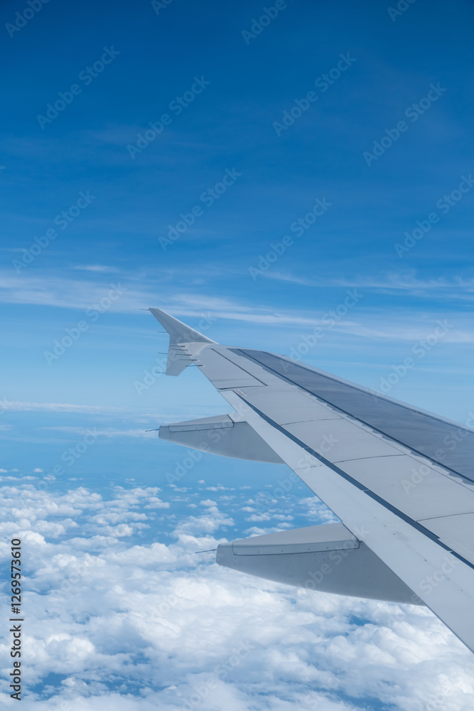 Sky and cloud seen through the window of airplane, with the plane wing Sky and cloud seen through the window of airplane, with the plane wing