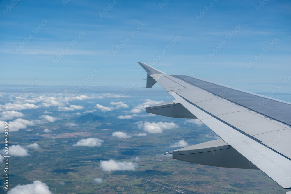 Sky and cloud seen through the window of airplane, with the plane wing Sky and cloud seen through the window of airplane, with the plane wing