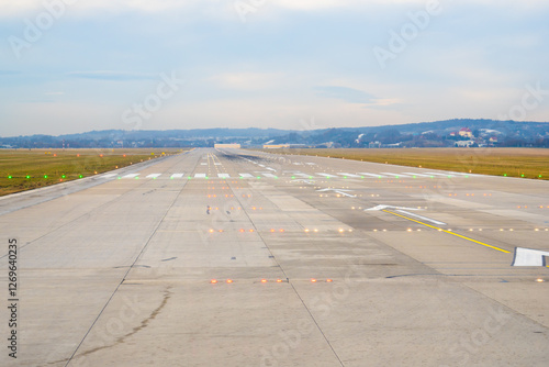 Runway view at an airport showing clear path for takeoff on a cloudy day