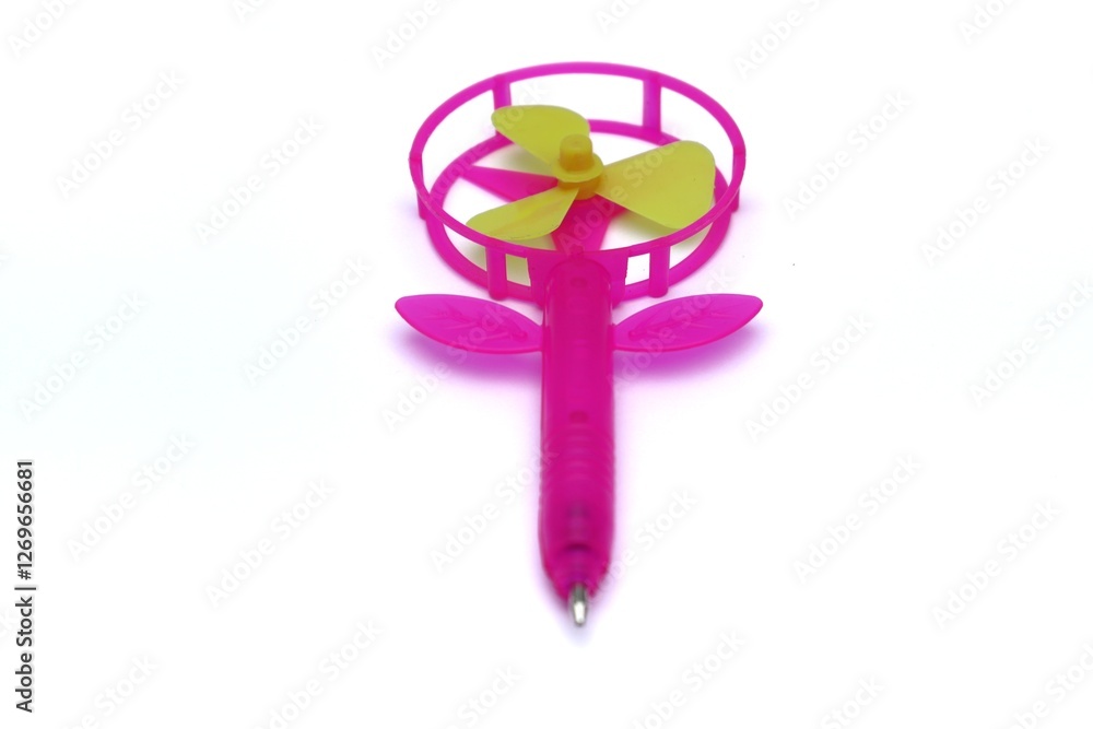 Pink flower shaped pen with a mini fan on a clean white background. Pink flower shaped pen with a mini fan on a clean white background.