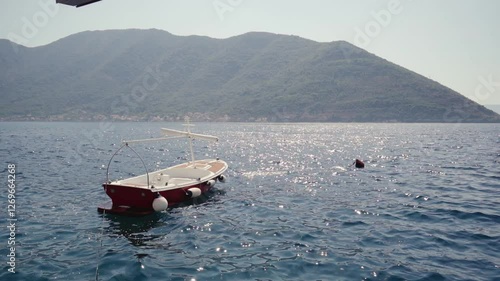 Boat on the waves against the backdrop of Mount Montenegro
