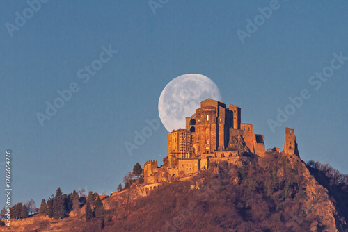 La Luna tramonta dietro la Sacra di San Michele alla Golden Hour photo