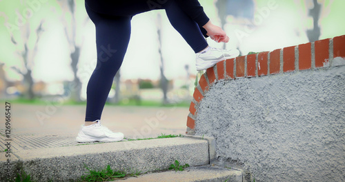 Obraz na płótnie Curvy latina woman tying shoelaces before exercising outdoors w salonie