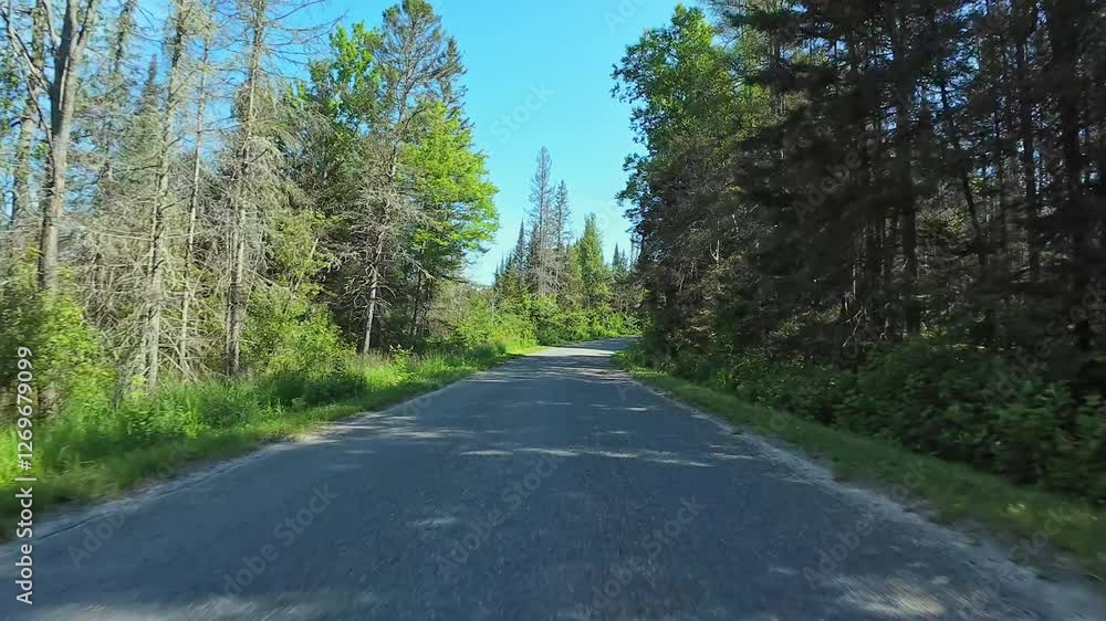 Empty highway freeway front driver plate at the Burk's Falls, Pickerel Lake, during hot July summer. Driving motorhome caravan car for vacation and adventure in the Canadian cottage countryside. Empty highway freeway front driver plate at the Burk's Falls, Pickerel Lake, during hot July summer. Driving motorhome caravan car for vacation and adventure in the Canadian cottage countryside.