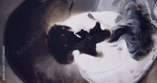 Grunge flow. Black ink. Swirling spread of dark pigment wet white surface texture. Smoky mystical curls mix in water abstract background.