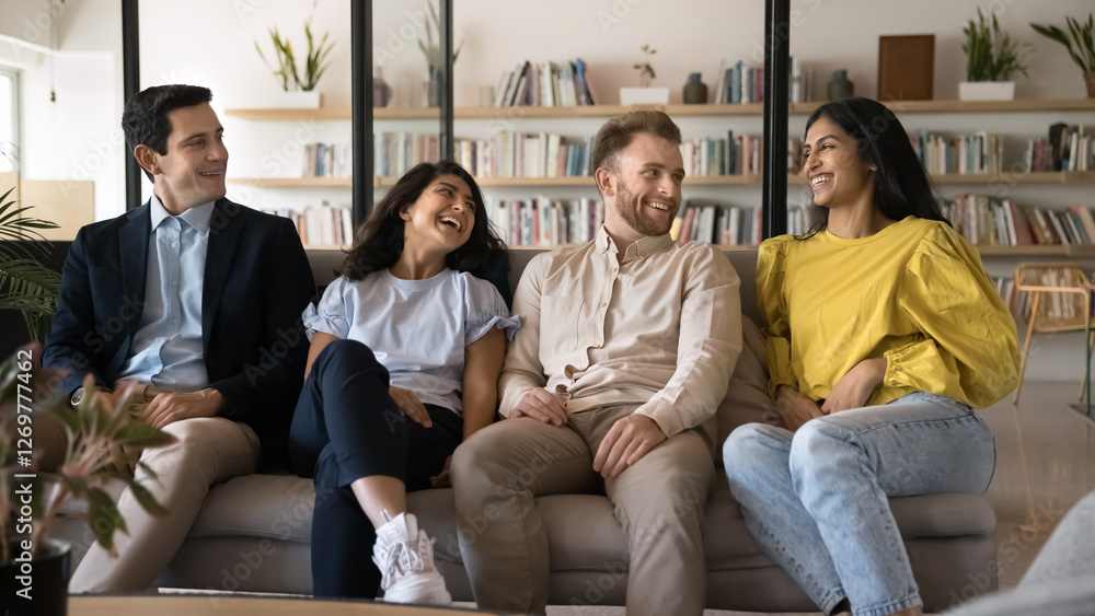 Pause in learning. Happy diverse multiethnic students workshop participants creative group relax on couch at library take break from studying developing project chat laugh enjoy informal communication