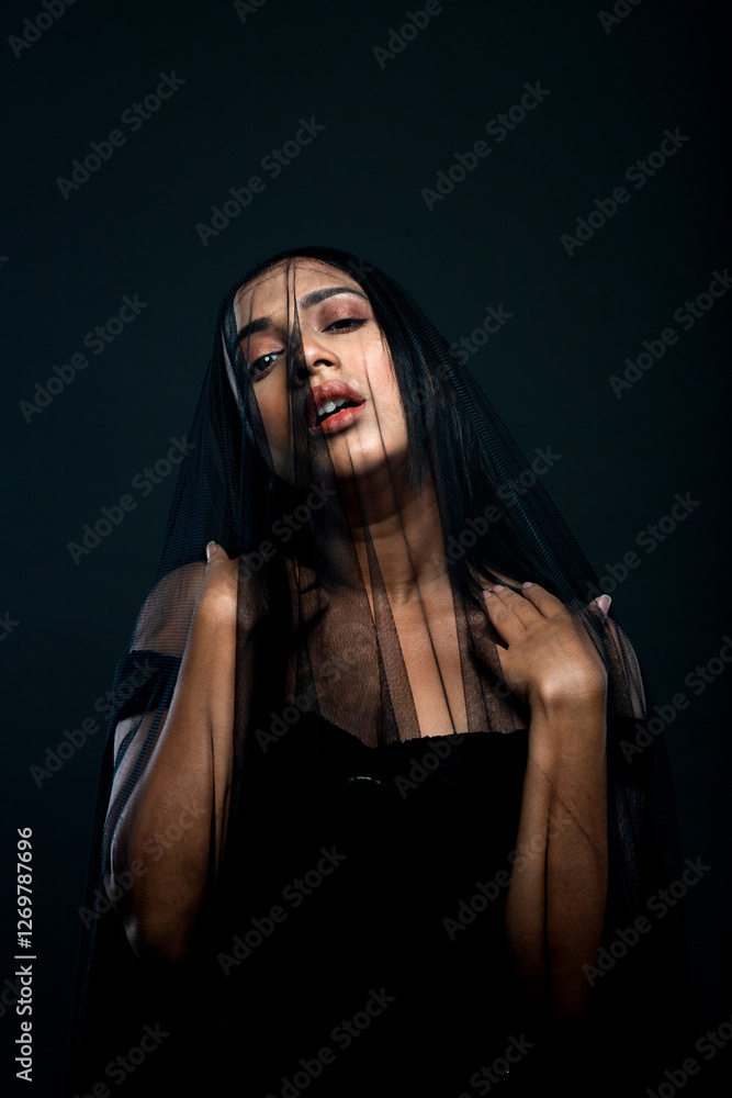 a beautiful female model with a face covered with a black veil. a beautiful female model with a face covered with a black veil.