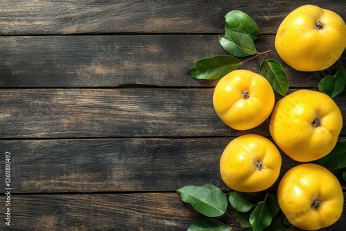 Organic quinces with leaves on a wooden table viewed from above Room for text