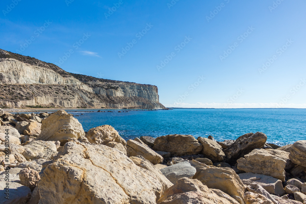 Zapallo Bay Beach in Cyprus: Sandy Shore, Rocks in the Sea, White Cliff, Sunny Day Zapallo Bay Beach in Cyprus: Sandy Shore, Rocks in the Sea, White Cliff, Sunny Day