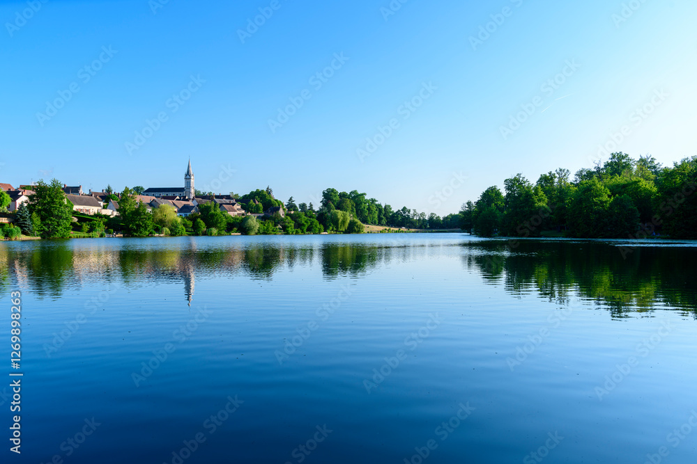 Dampierre-en-Burly view from the pond in Europe, France, Centre Val de Loire, Loiret, Dampierre en Burly, in summer, on a sunny day. Dampierre-en-Burly view from the pond in Europe, France, Centre Val de Loire, Loiret, Dampierre en Burly, in summer, on a sunny day.