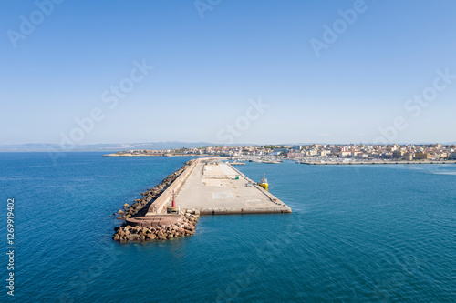 The breakwater at the entrance to the harbor in Porto Torres in Europe, Italy, Sardinia, Porto Torres, in summer, on a sunny day.