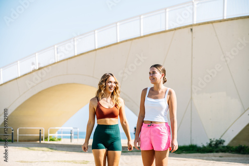 Wallpaper Mural Two young women walking and talking under white bridge Torontodigital.ca