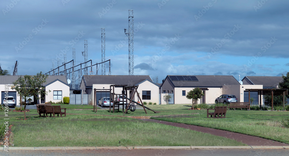 Modern suburban homes lined up in a peaceful neighbourhood. Residential area, real estate development, or new beginnings concept. Architecture and tranquil living. Modern suburban homes lined up in a peaceful neighbourhood. Residential area, real estate development, or new beginnings concept. Architecture and tranquil living.