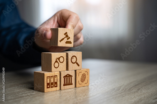 A man assembles a judicial system from blocks in the shape of a pyramid. Legal hierarchy, law enforcement, and justice system organization.