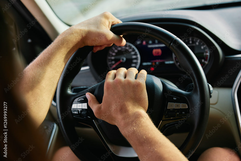 Naklejka premium Hands gripping a steering wheel while driving a car with a focus on the dashboard and speedometer