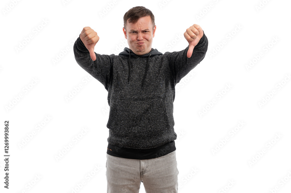 A young man in a gray hoodie making a thumbs down gesture against a white background. A young man in a gray hoodie making a thumbs down gesture against a white background.