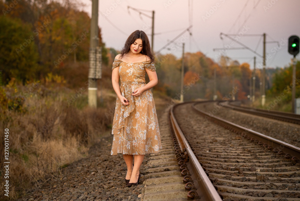 Elegant Woman in Evening Dress on Railway Tracks During Sunset. Depressed mood Elegant Woman in Evening Dress on Railway Tracks During Sunset. Depressed mood
