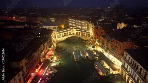 Aerial view of Venice, Italy featuring the famous Rialto Bridge and gondolas traveling through the Grand Canal