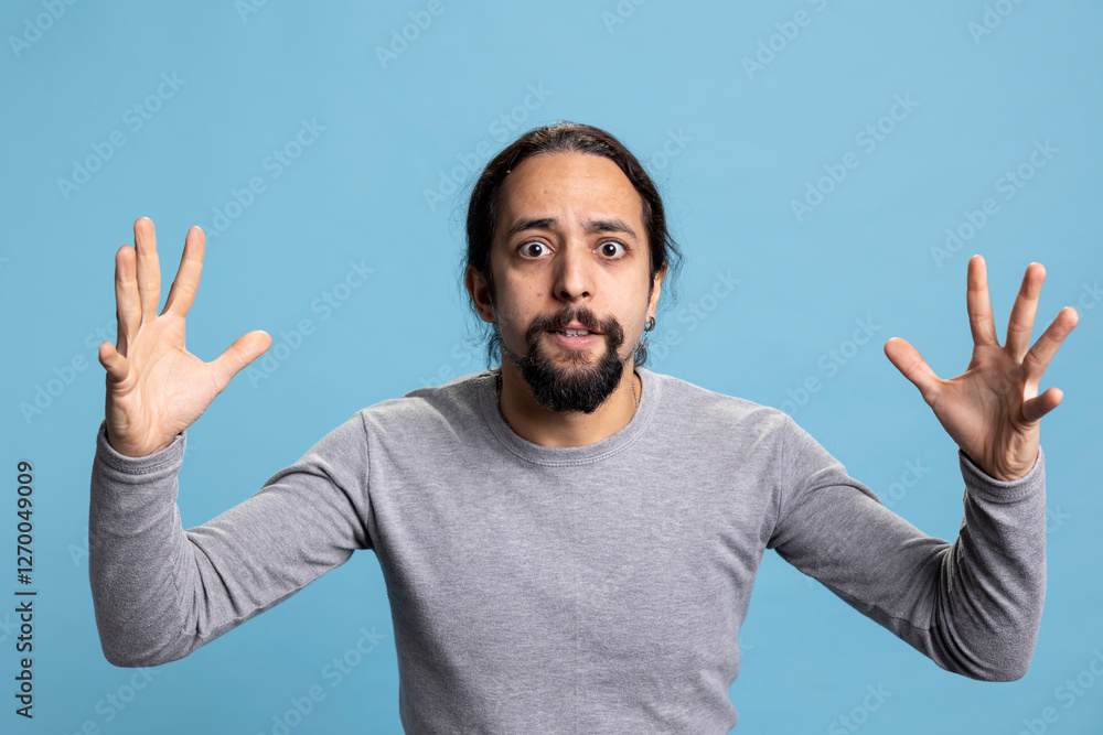 Fototapeta premium Frustrated angry person expressing his intense emotions and anxiety on camera, showcasing anger management issues and rage. Young adult being furious and irritated with something in studio.