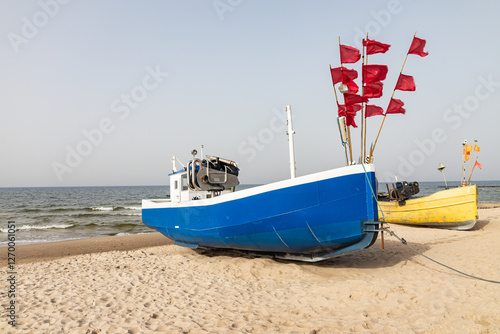 Kuter rybacki na plaży nad polskim morzem. Sieci połów