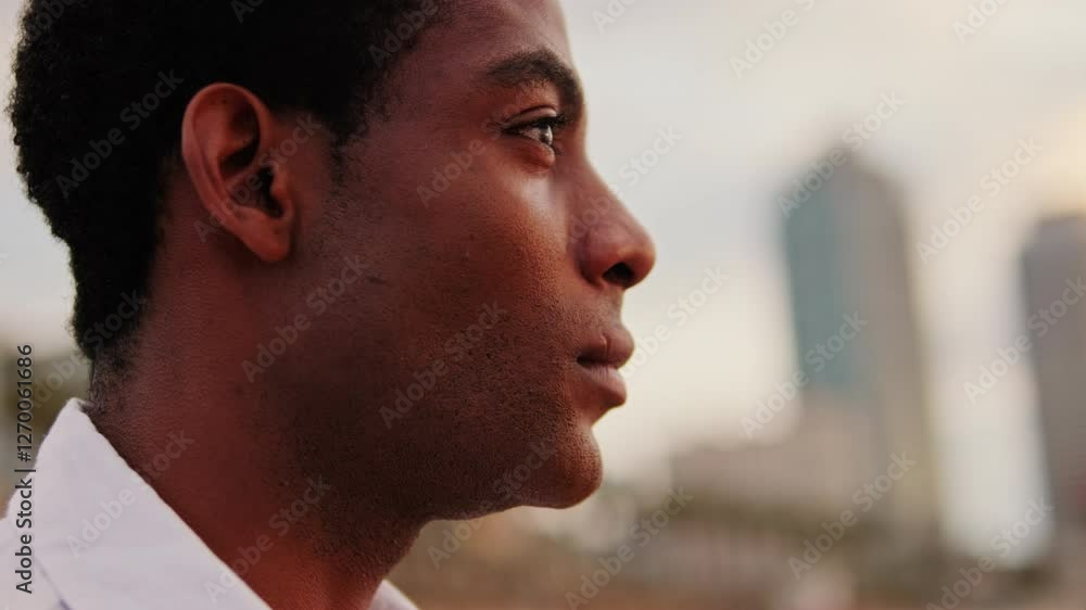 custom made wallpaper toronto digitalYoung man looks thoughtfully at the city skyline during sunset. He appears contemplative and hopeful about the future.