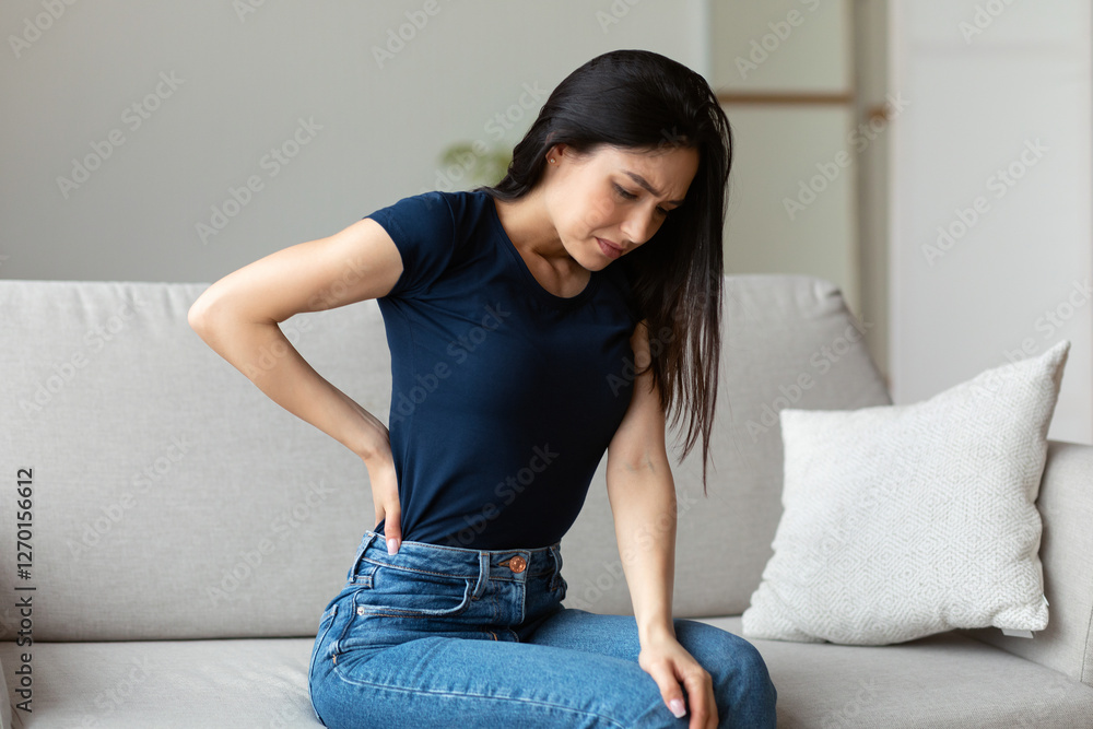 Back Pain. Woman Suffering From Backache Having Spine Problems Sitting On Couch At Home. Back Pain. Woman Suffering From Backache Having Spine Problems Sitting On Couch At Home.