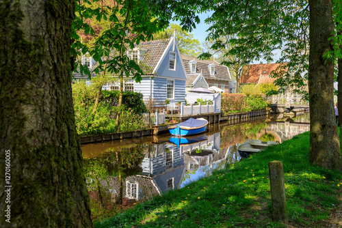Europe, The Netherlands, North Holland. Broek in Waterland. Reflections along a small canal.